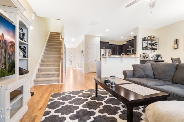 living room with ceiling fan and light wood-type flooring