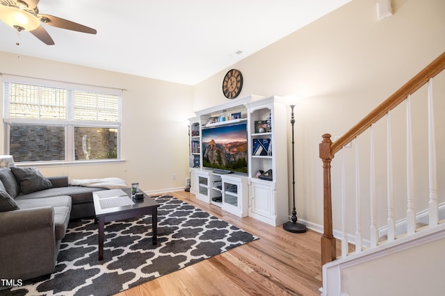 living room with light wood-type flooring, ceiling fan, and lofted ceiling