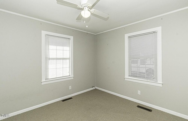 empty room featuring ceiling fan, crown molding, and carpet floors