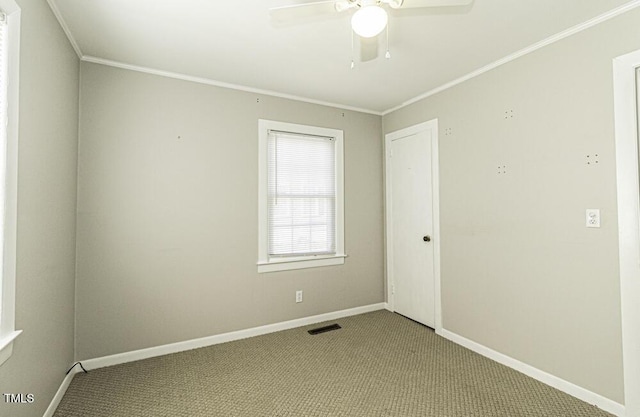 carpeted empty room with ceiling fan and crown molding