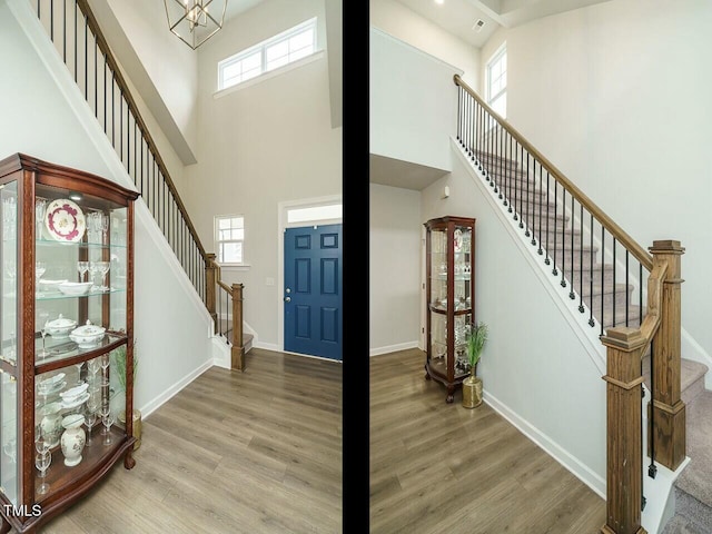 entrance foyer with hardwood / wood-style floors and a towering ceiling