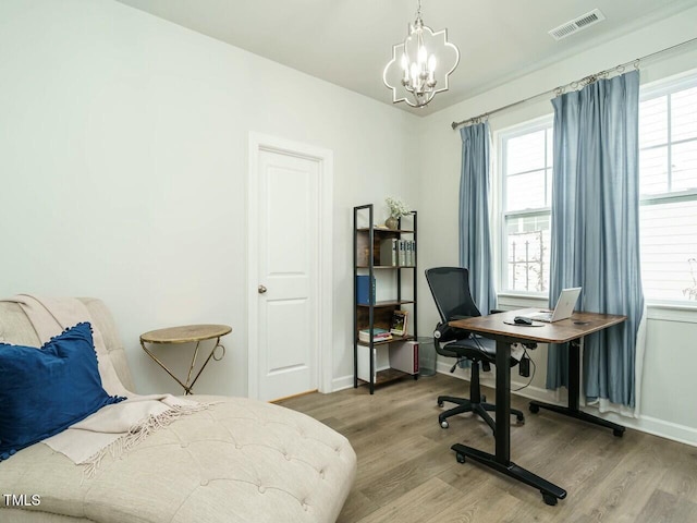 bedroom featuring a notable chandelier and hardwood / wood-style flooring