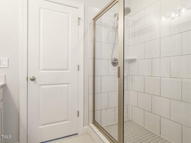 bathroom with tile patterned floors, walk in shower, and vanity