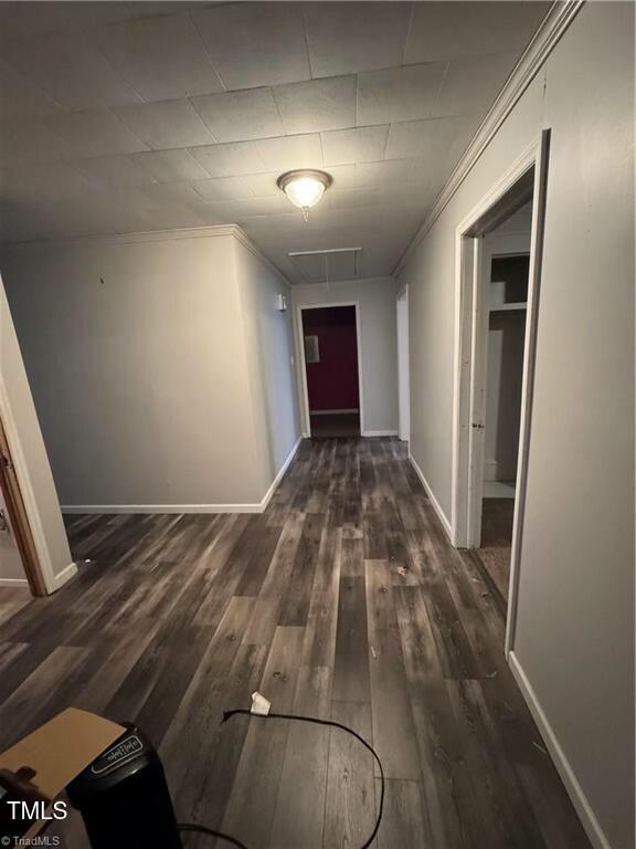 hall with ornamental molding and dark hardwood / wood-style flooring