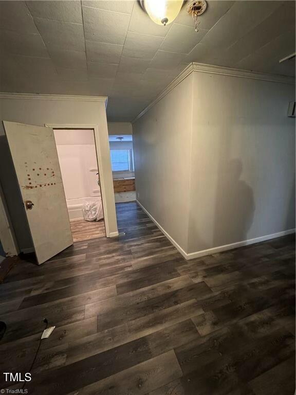 hallway featuring crown molding and dark hardwood / wood-style flooring