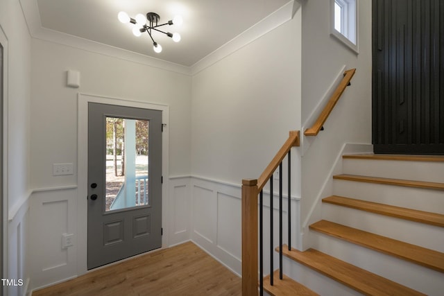 entryway featuring crown molding and light hardwood / wood-style floors