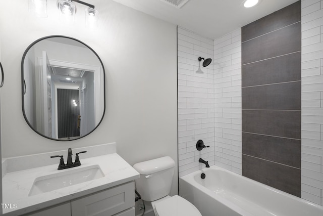 full bathroom with tiled shower / bath, vanity, and toilet