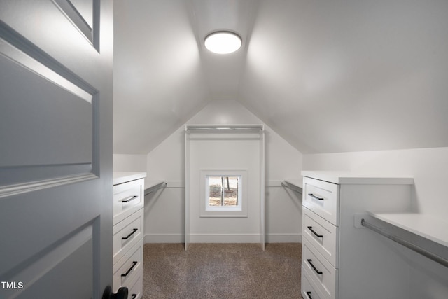 spacious closet featuring dark colored carpet and vaulted ceiling