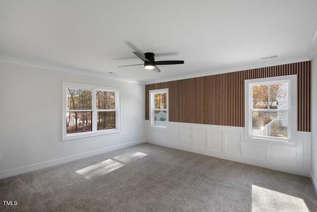 unfurnished room featuring crown molding, ceiling fan, carpet floors, and a wealth of natural light