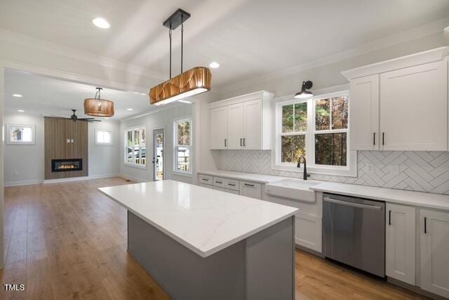 kitchen with a kitchen island, pendant lighting, dishwasher, white cabinets, and decorative backsplash