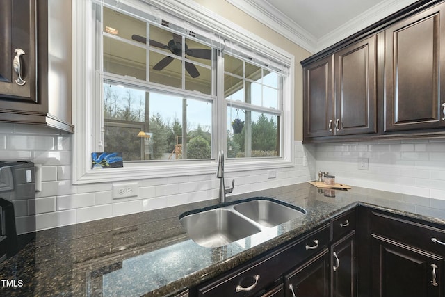 kitchen featuring sink, dark stone counters, decorative backsplash, ornamental molding, and dark brown cabinets