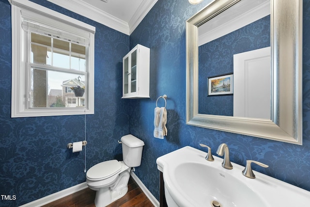 bathroom featuring wood-type flooring, sink, ornamental molding, and toilet