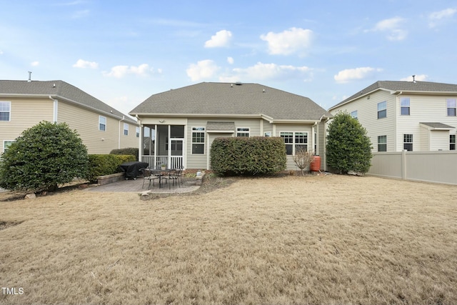 back of house featuring a patio area, a sunroom, and a lawn