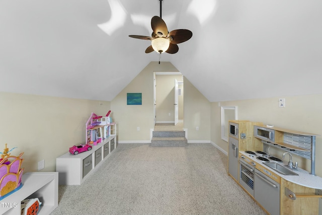 game room featuring vaulted ceiling, sink, light carpet, and ceiling fan