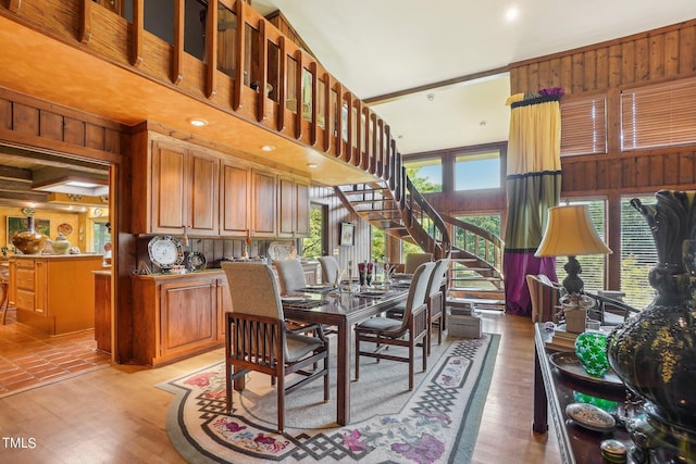 dining room featuring light hardwood / wood-style flooring and wooden walls