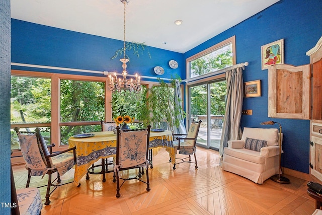 dining space with light parquet floors and a chandelier