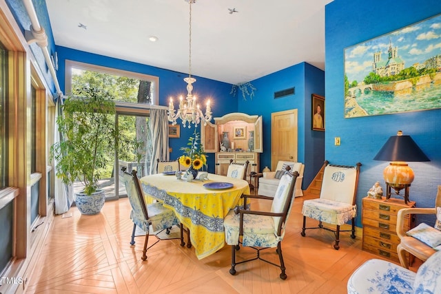 dining area featuring light parquet floors and a notable chandelier