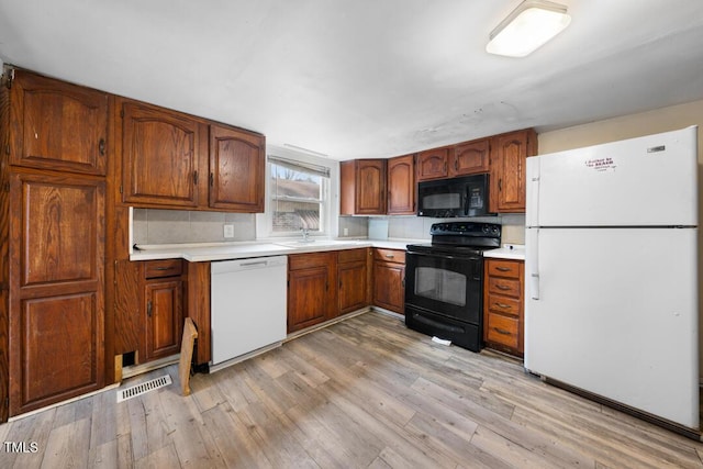 kitchen featuring light hardwood / wood-style flooring and black appliances