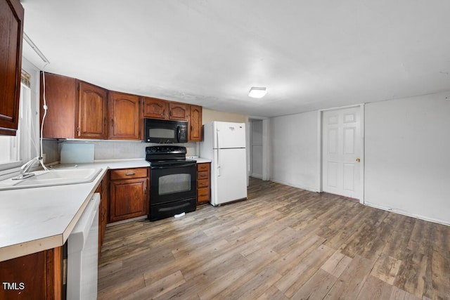 kitchen with sink, light hardwood / wood-style flooring, and black appliances