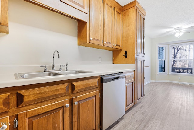 kitchen featuring dishwasher, sink, ceiling fan, light hardwood / wood-style floors, and a textured ceiling