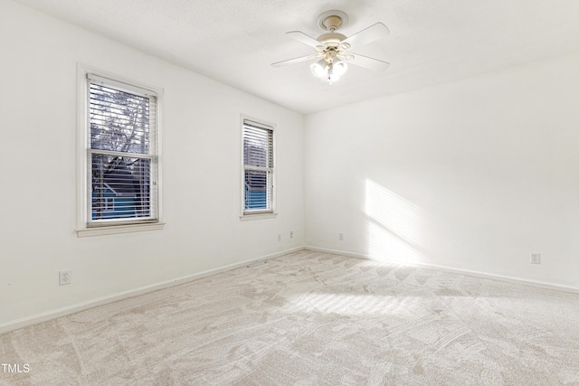 carpeted spare room with ceiling fan