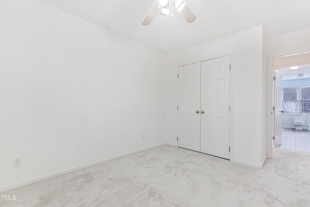 unfurnished bedroom featuring light colored carpet, ceiling fan, and a closet