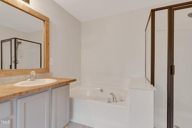 bathroom with vanity and shower with separate bathtub