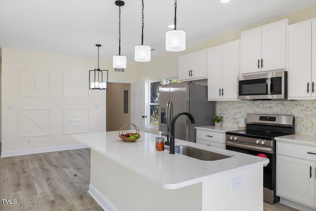 kitchen featuring white cabinetry, appliances with stainless steel finishes, sink, and a kitchen island with sink