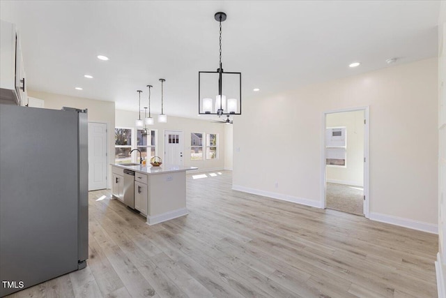 kitchen featuring white cabinetry, an island with sink, appliances with stainless steel finishes, and pendant lighting