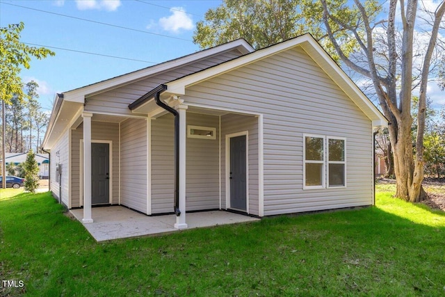 rear view of house with a yard and a patio area