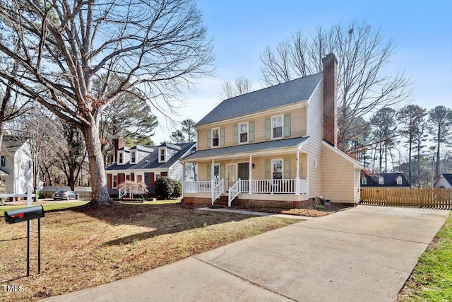 colonial inspired home with a porch and a front lawn