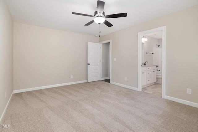 unfurnished bedroom with ceiling fan, connected bathroom, sink, and light carpet