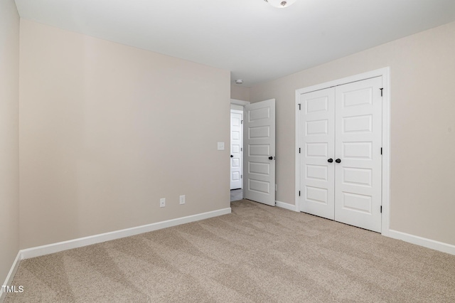 unfurnished bedroom featuring light carpet and a closet