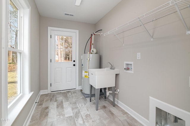 washroom featuring plenty of natural light, electric water heater, and washer hookup