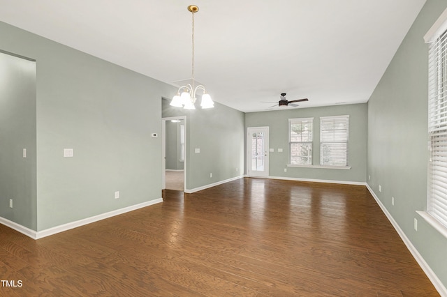 spare room featuring dark hardwood / wood-style floors and ceiling fan with notable chandelier