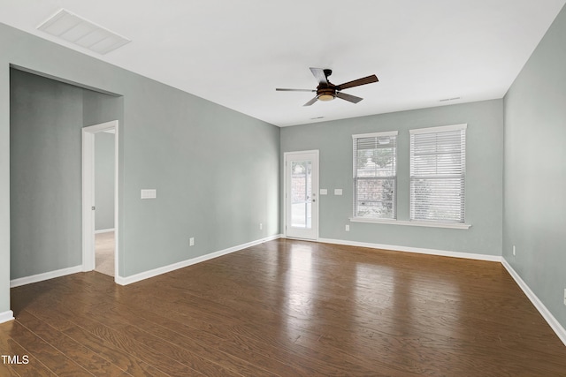 empty room with ceiling fan and dark hardwood / wood-style flooring