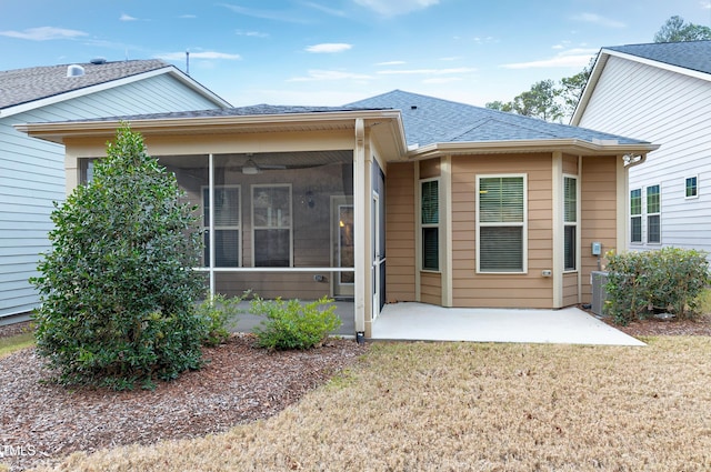 rear view of house featuring central AC unit, a sunroom, a yard, ceiling fan, and a patio