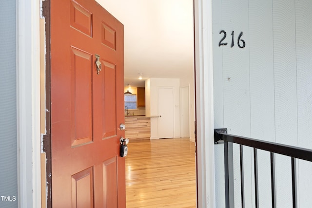 hallway with sink and light hardwood / wood-style flooring