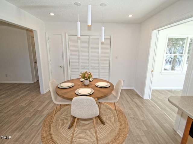 dining area featuring light hardwood / wood-style floors and a textured ceiling