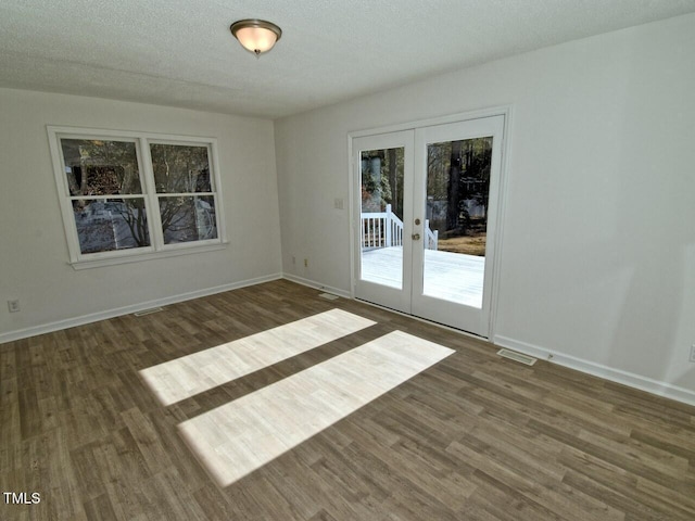 spare room with dark hardwood / wood-style floors, a textured ceiling, and french doors