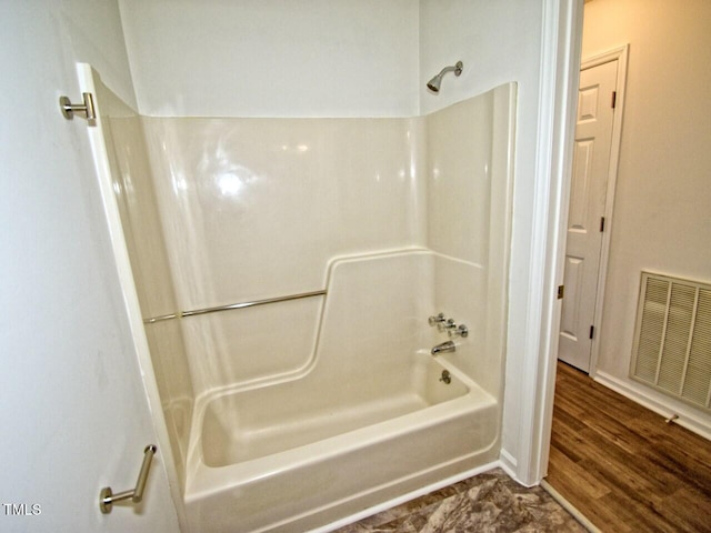 bathroom with shower / bath combination and hardwood / wood-style floors