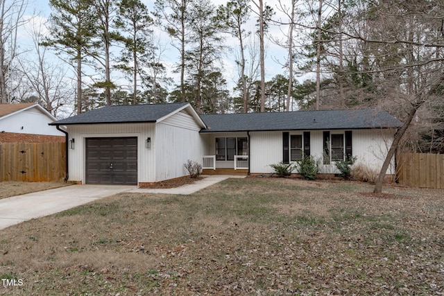 ranch-style home featuring covered porch, a front lawn, and a garage