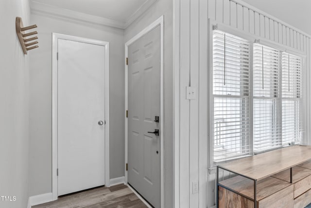 foyer entrance with crown molding and light hardwood / wood-style floors