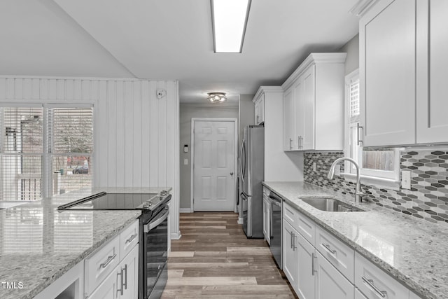 kitchen featuring sink, light stone counters, white cabinetry, and stainless steel appliances