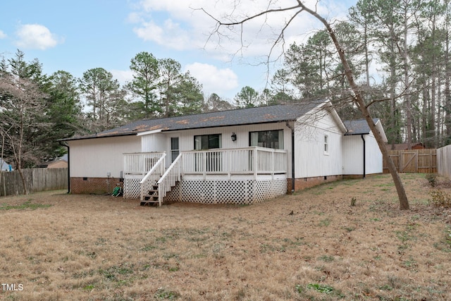 back of property with a wooden deck and a yard