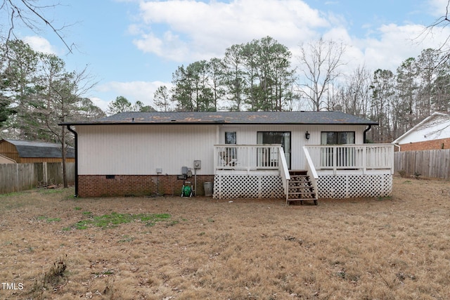 rear view of house with a lawn and a wooden deck