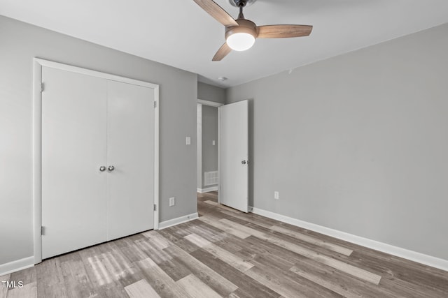 unfurnished bedroom featuring light wood-type flooring, a closet, and ceiling fan