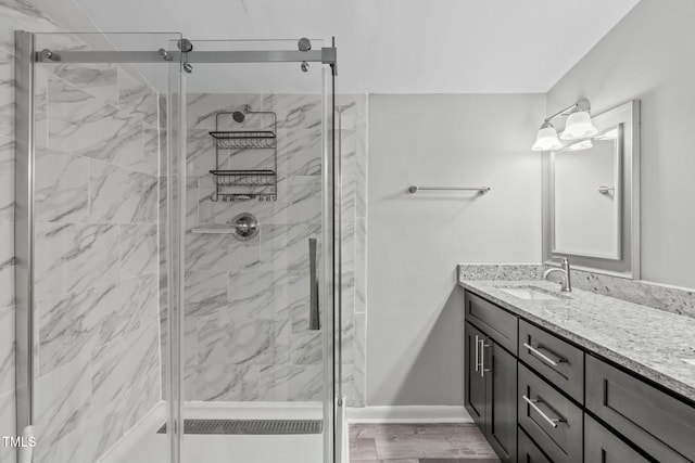 bathroom featuring vanity, a shower with door, and wood-type flooring