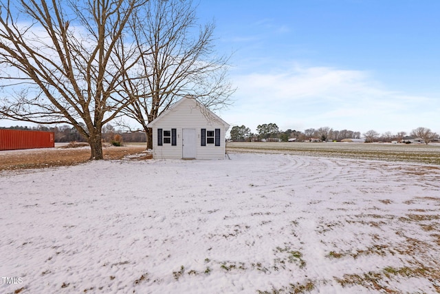 snow covered property featuring an outdoor structure