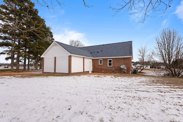 snow covered property with central AC unit